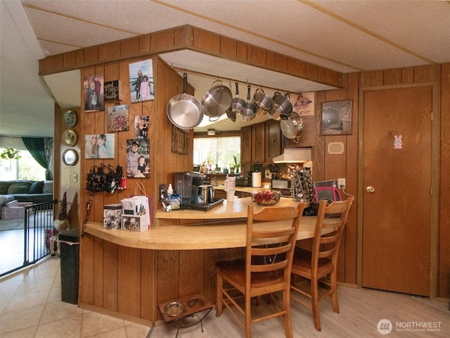 81 Robbins Rd, Sequim, WA 98382 - kitchen with wood walls, range hood, and brown cabinets