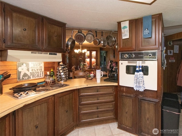 81 Robbins Rd, Sequim, WA 98382 - kitchen with oven, under cabinet range hood, stainless steel electric stovetop, light countertops, and a chandelier