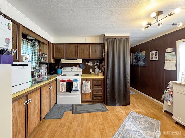 81 Robbins Rd, Sequim, WA 98382 - kitchen with white electric range, under cabinet range hood, light countertops, light wood-style floors, and a sink