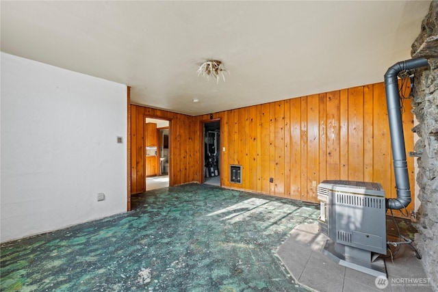 1203 S 8th Ave, Yakima, WA 98902 - unfurnished living room with a wood stove, heating unit, and wooden walls