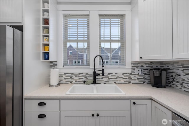 29 Laurel Ln, Pacific Beach, WA 98571 - kitchen featuring a sink, stainless steel fridge, backsplash, and white cabinets
