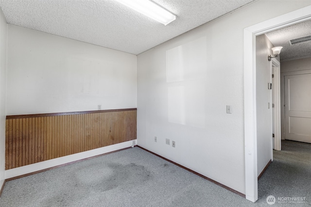 1023 W Stewart Ave, Puyallup, WA 98371 - carpeted spare room with a textured ceiling, wood walls, and wainscoting
