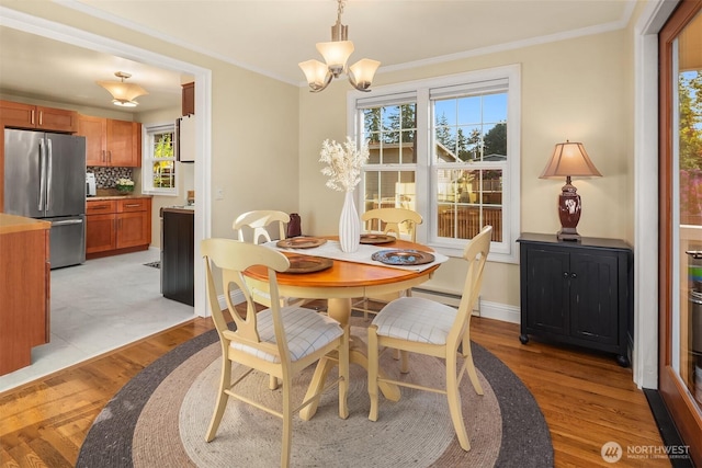 8724 Main St, Edmonds, WA 98026 - dining room with light wood-type flooring, healthy amount of natural light, a chandelier, crown molding, and baseboard heating