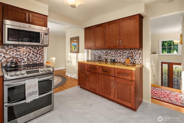 8724 Main St, Edmonds, WA 98026 - kitchen featuring appliances with stainless steel finishes, backsplash, light countertops, and baseboards