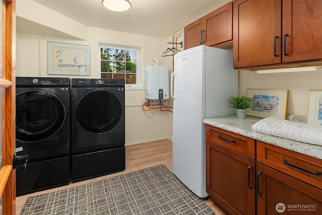 8724 Main St, Edmonds, WA 98026 - laundry room featuring water heater, washing machine and dryer, light wood finished floors, cabinet space, and baseboards