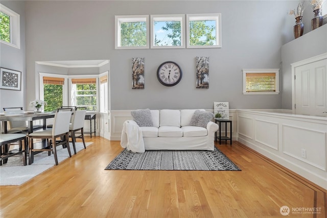 13374 SE 308th Ct, Auburn, WA 98092 - living room with a towering ceiling, light wood-style flooring, a decorative wall, and wainscoting