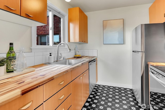 330 W Olympic Pl Unit 302, Seattle, WA 98119 - kitchen with a sink, butcher block counters, tile patterned floors, stainless steel appliances, and baseboards