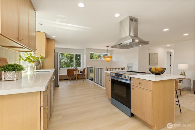 5134 S Wallace St, Seattle, WA 98178 - kitchen featuring island exhaust hood, stainless steel appliances, light brown cabinets, light wood-style floors, and a breakfast bar