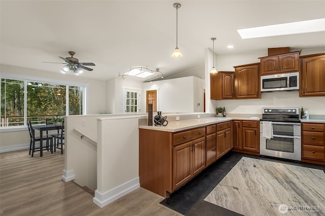 110 E Sea Breeze Dr, Grapeview, WA 98546 - kitchen with appliances with stainless steel finishes, a skylight, light countertops, a peninsula, and baseboards