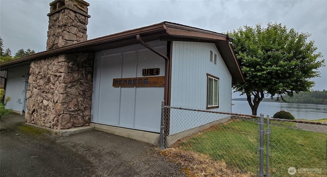 110 E Sea Breeze Dr, Grapeview, WA 98546 - view of side of home with a chimney, stone siding, and a water view