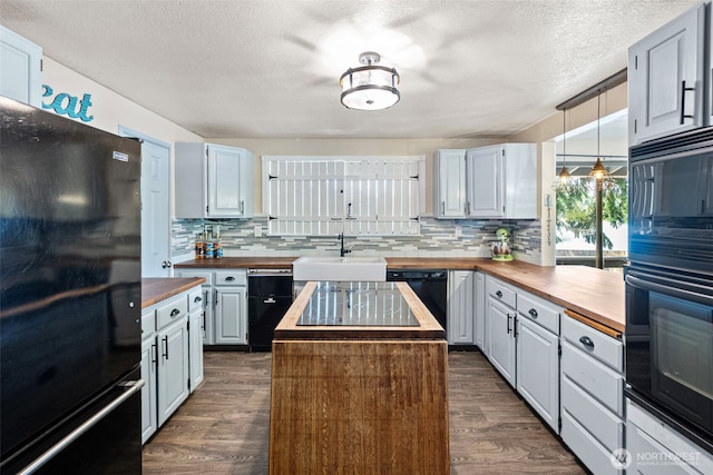 268 Kingsway W, Bremerton, WA 98312 - kitchen with butcher block counters, black appliances, tasteful backsplash, dark wood-type flooring, and a textured ceiling