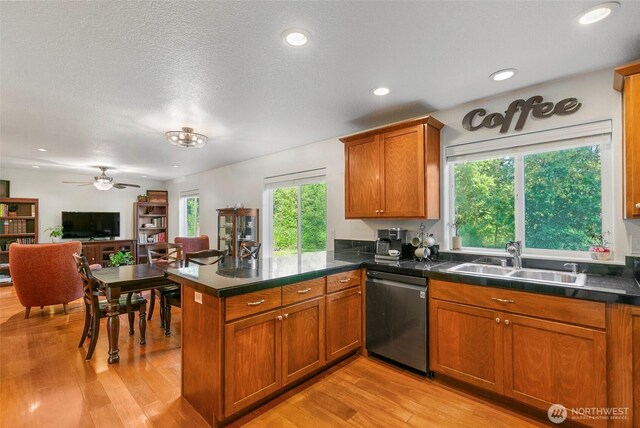 34821 NE Gable Ave, La Center, WA 98629 - kitchen featuring dishwasher, a peninsula, light wood-type flooring, brown cabinets, and dark countertops