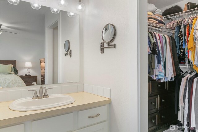34821 NE Gable Ave, La Center, WA 98629 - bathroom featuring vanity, a ceiling fan, and a walk in closet