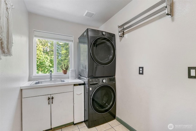 34821 NE Gable Ave, La Center, WA 98629 - laundry room with estacked washer and dryer, cabinet space, and light tile patterned flooring