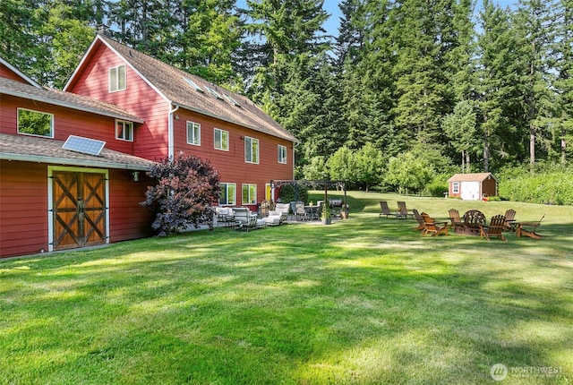 34821 NE Gable Ave, La Center, WA 98629 - view of green lawn with a shed, an outdoor fire pit, and a patio area
