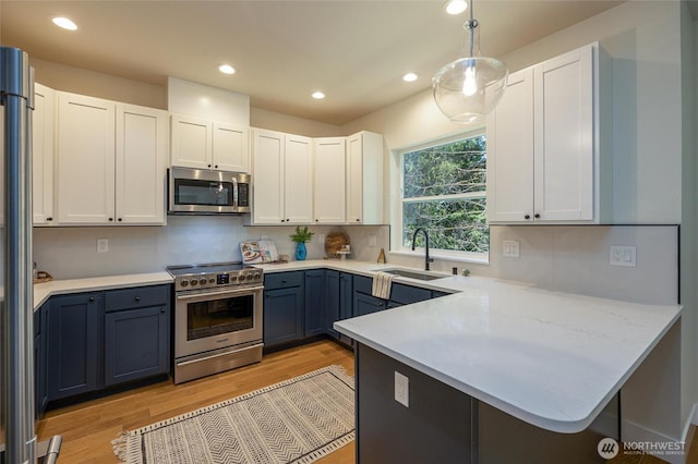 11 Kinglet Ct, Bellingham, WA 98229 - kitchen with appliances with stainless steel finishes, a sink, a peninsula, light wood-type flooring, and recessed lighting