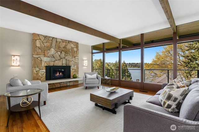 2019 Killarney Way, Bellevue, WA 98004 - living room featuring beam ceiling, wood finished floors, and a stone fireplace