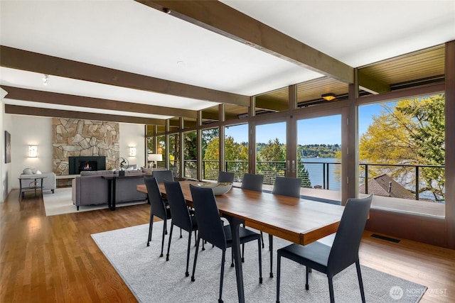 2019 Killarney Way, Bellevue, WA 98004 - dining space with beamed ceiling, wood finished floors, a fireplace, and a water view
