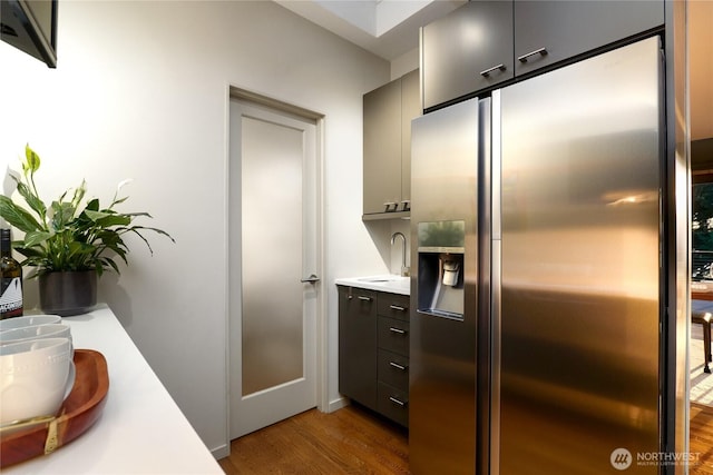 2019 Killarney Way, Bellevue, WA 98004 - kitchen with stainless steel fridge with ice dispenser, wood finished floors, a sink, light countertops, and modern cabinets