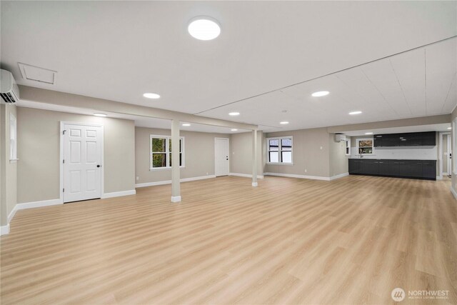 11101 Bingham Ave E, Tacoma, WA 98446 - unfurnished living room with an AC wall unit, light wood-style floors, baseboards, recessed lighting, and healthy amount of natural light