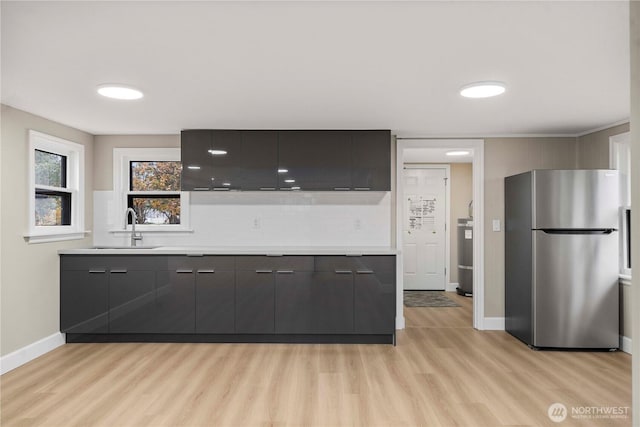 11101 Bingham Ave E, Tacoma, WA 98446 - bar with freestanding refrigerator, a sink, light wood-style flooring, and tasteful backsplash
