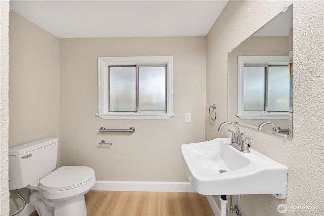 11101 Bingham Ave E, Tacoma, WA 98446 - half bathroom with wood finished floors, toilet, baseboards, and a sink