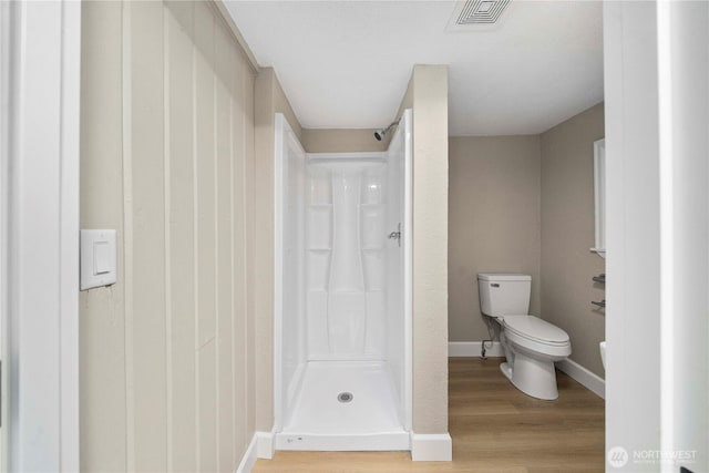 11101 Bingham Ave E, Tacoma, WA 98446 - bathroom featuring toilet, a shower stall, wood finished floors, and baseboards