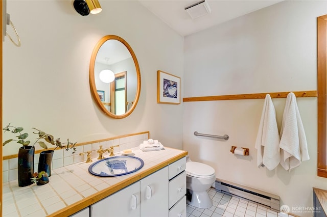 317 Eagles Roost Ln, Lopez Island, WA 98261 - bathroom with a baseboard heating unit, vanity, toilet, and tile patterned floors