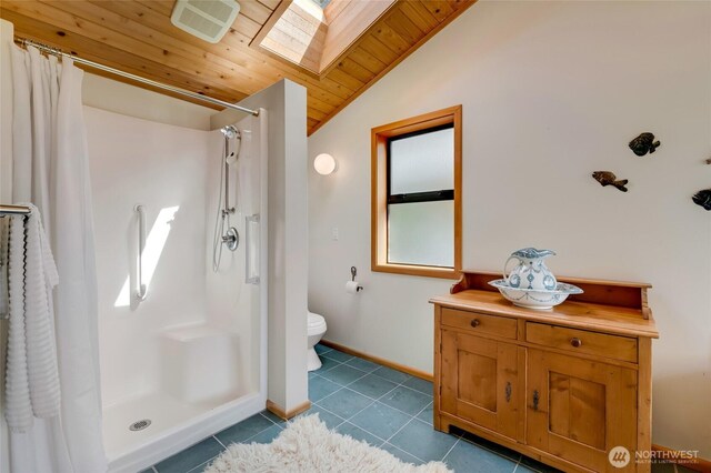 317 Eagles Roost Ln, Lopez Island, WA 98261 - bathroom with a skylight, vaulted ceiling, toilet, curtained shower, and tile patterned flooring