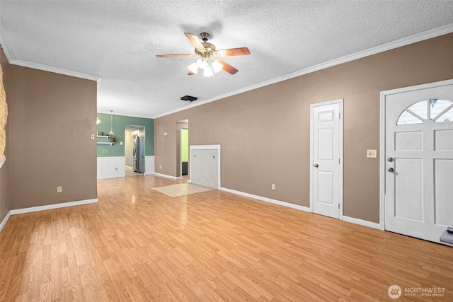 3710 Rucker Ave, Everett, WA 98201 - unfurnished living room featuring light wood-style flooring, a ceiling fan, a textured ceiling, crown molding, and baseboards