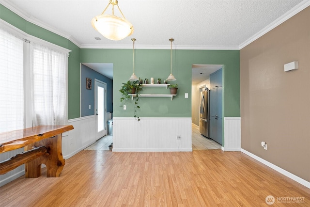 3710 Rucker Ave, Everett, WA 98201 - dining space featuring healthy amount of natural light, light wood-type flooring, a wainscoted wall, crown molding, and a textured ceiling