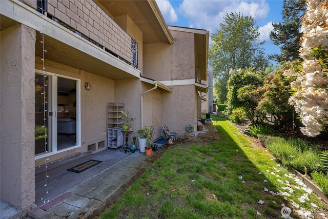 20110 60th Ave W Unit F26, Lynnwood, WA 98036 - view of side of home featuring stucco siding, a yard, and a patio area