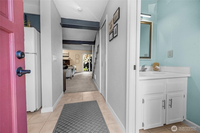 20110 60th Ave W Unit F26, Lynnwood, WA 98036 - corridor with a sink, light tile patterned flooring, and baseboards