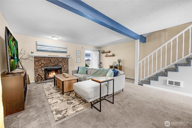 20110 60th Ave W Unit F26, Lynnwood, WA 98036 - carpeted living room with beamed ceiling, stairway, a textured ceiling, a stone fireplace, and baseboards