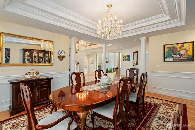 4180 April Dr, Wenatchee, WA 98801 - dining space featuring ornate columns, a raised ceiling, crown molding, light wood-type flooring, and a decorative wall
