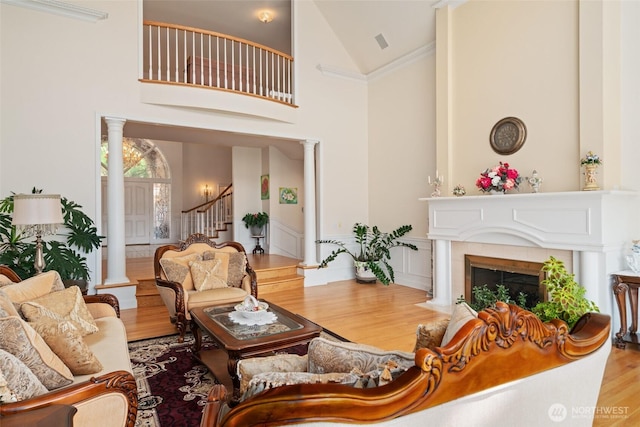 4180 April Dr, Wenatchee, WA 98801 - living room with decorative columns, wood finished floors, high vaulted ceiling, stairway, and a tiled fireplace