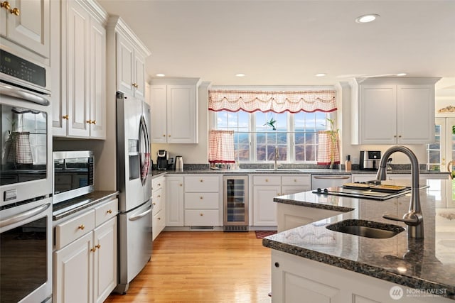 4180 April Dr, Wenatchee, WA 98801 - kitchen featuring beverage cooler, appliances with stainless steel finishes, a sink, recessed lighting, and white cabinets