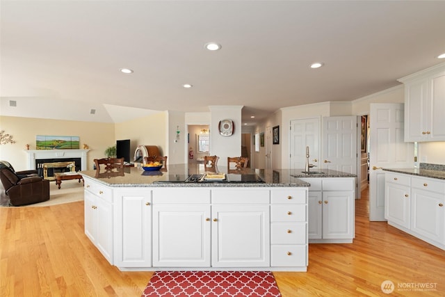 4180 April Dr, Wenatchee, WA 98801 - kitchen with a sink, a center island, a fireplace, light wood-style floors, and open floor plan
