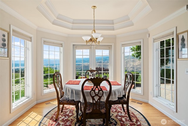 4180 April Dr, Wenatchee, WA 98801 - dining area with a chandelier, healthy amount of natural light, light wood-type flooring, ornamental molding, and a raised ceiling