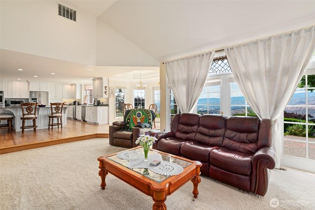 4180 April Dr, Wenatchee, WA 98801 - living room with light carpet, high vaulted ceiling, a chandelier, and recessed lighting