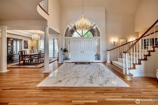 4180 April Dr, Wenatchee, WA 98801 - entrance foyer featuring a chandelier, a towering ceiling, stairs, wood finished floors, and decorative columns