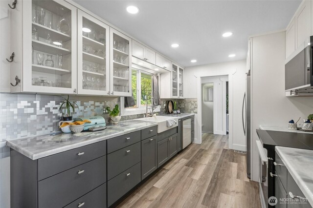 3161 Locust Ave, Bellingham, WA 98225 - kitchen featuring a sink, stainless steel dishwasher, white cabinets, range, and light wood finished floors