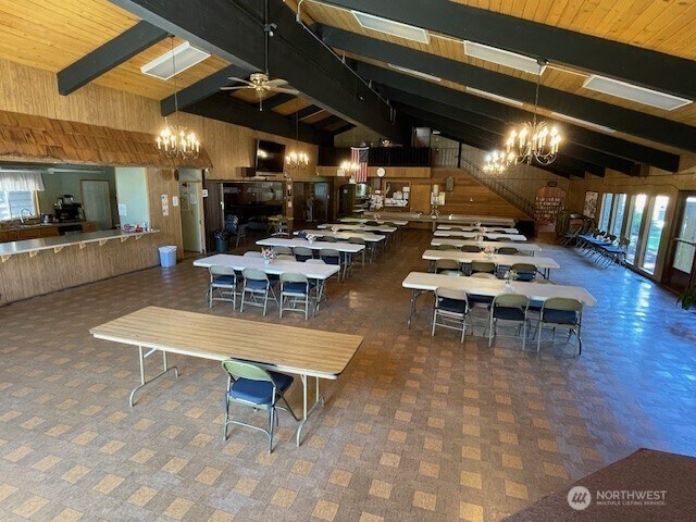 11410 127th St E Unit 185, Puyallup, WA 98374 - dining area with a chandelier, wooden walls, healthy amount of natural light, wooden ceiling, and a ceiling fan
