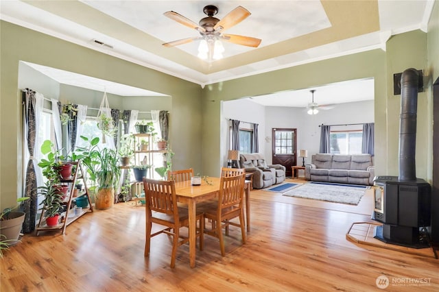 108 2nd St SE, Rainier, WA 98576 - dining room with ceiling fan, a wood stove, healthy amount of natural light, and ornamental molding