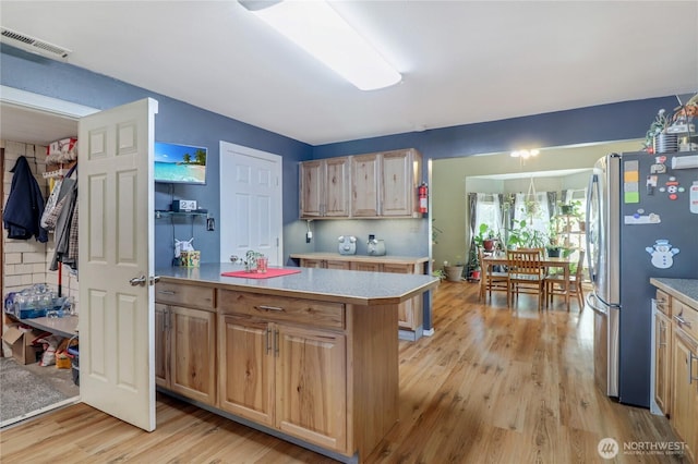 108 2nd St SE, Rainier, WA 98576 - kitchen with freestanding refrigerator, light wood-type flooring, and light countertops