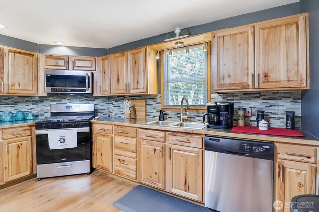 108 2nd St SE, Rainier, WA 98576 - kitchen featuring appliances with stainless steel finishes, a sink, light brown cabinets, light wood-style flooring, and recessed lighting