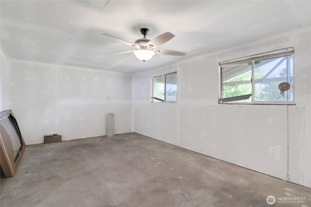 108 2nd St SE, Rainier, WA 98576 - spare room with concrete flooring, plenty of natural light, and a ceiling fan