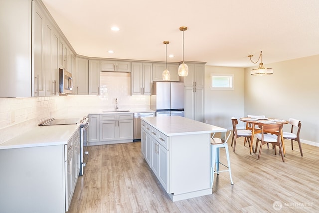 31810 I St, Ocean Park, WA 98640 - kitchen featuring stainless steel appliances, a center island, light wood-type flooring, decorative backsplash, and a breakfast bar area
