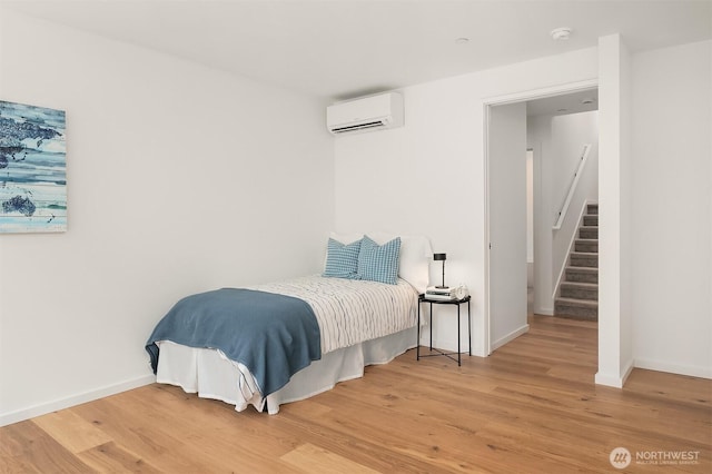 633 13th Ave E, Seattle, WA 98102 - bedroom featuring a wall mounted AC, light wood-type flooring, and baseboards