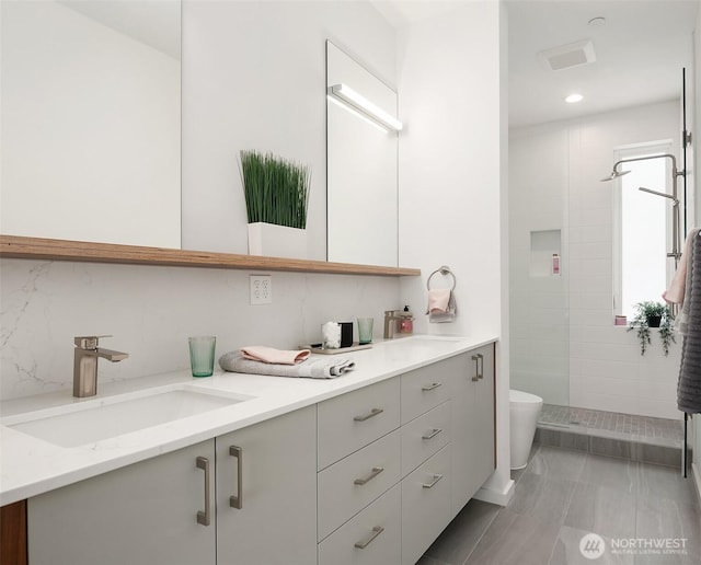 633 13th Ave E, Seattle, WA 98102 - bathroom featuring double vanity, toilet, a tile shower, and recessed lighting